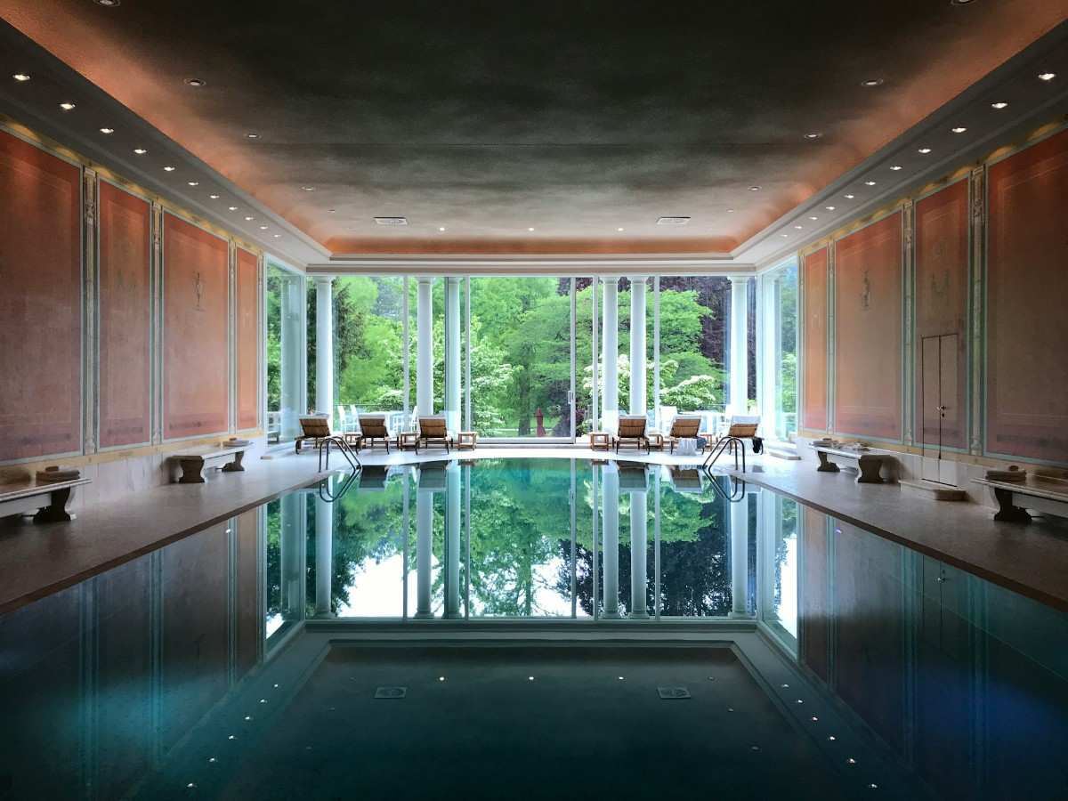a large indoor swimming pool with a view of the trees
